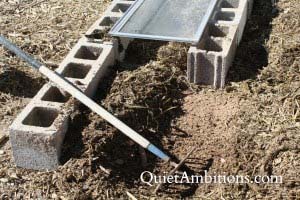 Raking up a layer of straw during the cold frame construction. 