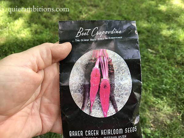 Sharon's hand  holding a pack of Beet Crapaudine Heirloom Seeds.